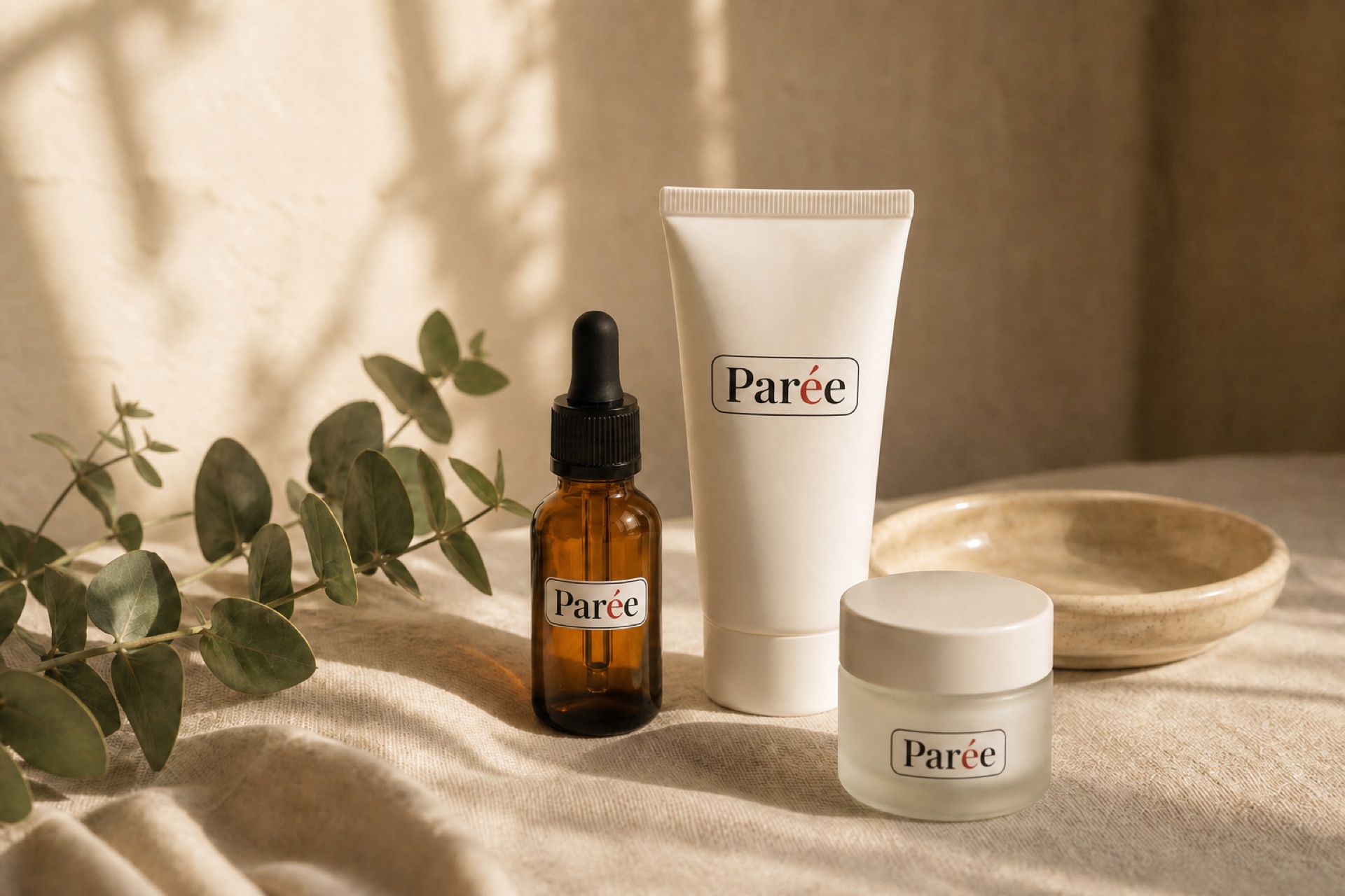 Parée treatment containers arranged on cream linen in soft natural light